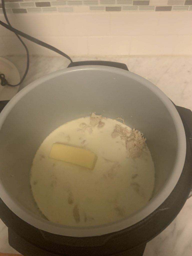 All of the ingredients of the Ninja Foodi Chicken Alfredo Soup melting