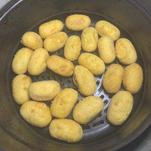 Place the frozen mini corn dogs in a single layer in the air fryer basket